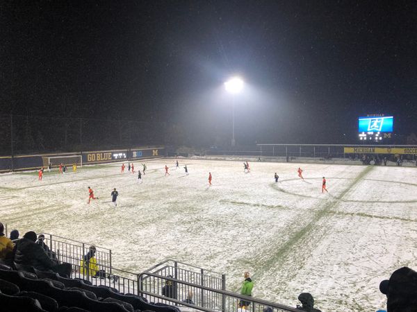 The University of Michigan and Princeton play men's soccer on a snowy field.