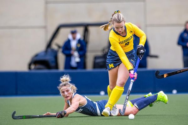 Field Hockey's Pilar Oliveros takes the ball past a fallen Nittany Lion.